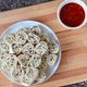 Plate of Cheesy Tortilla Roll-Ups beside bowl of red salsa on wooden cutting board